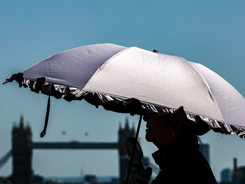 A woman walks with an umbrella on London Bridge on June 25, 2026. Visual China