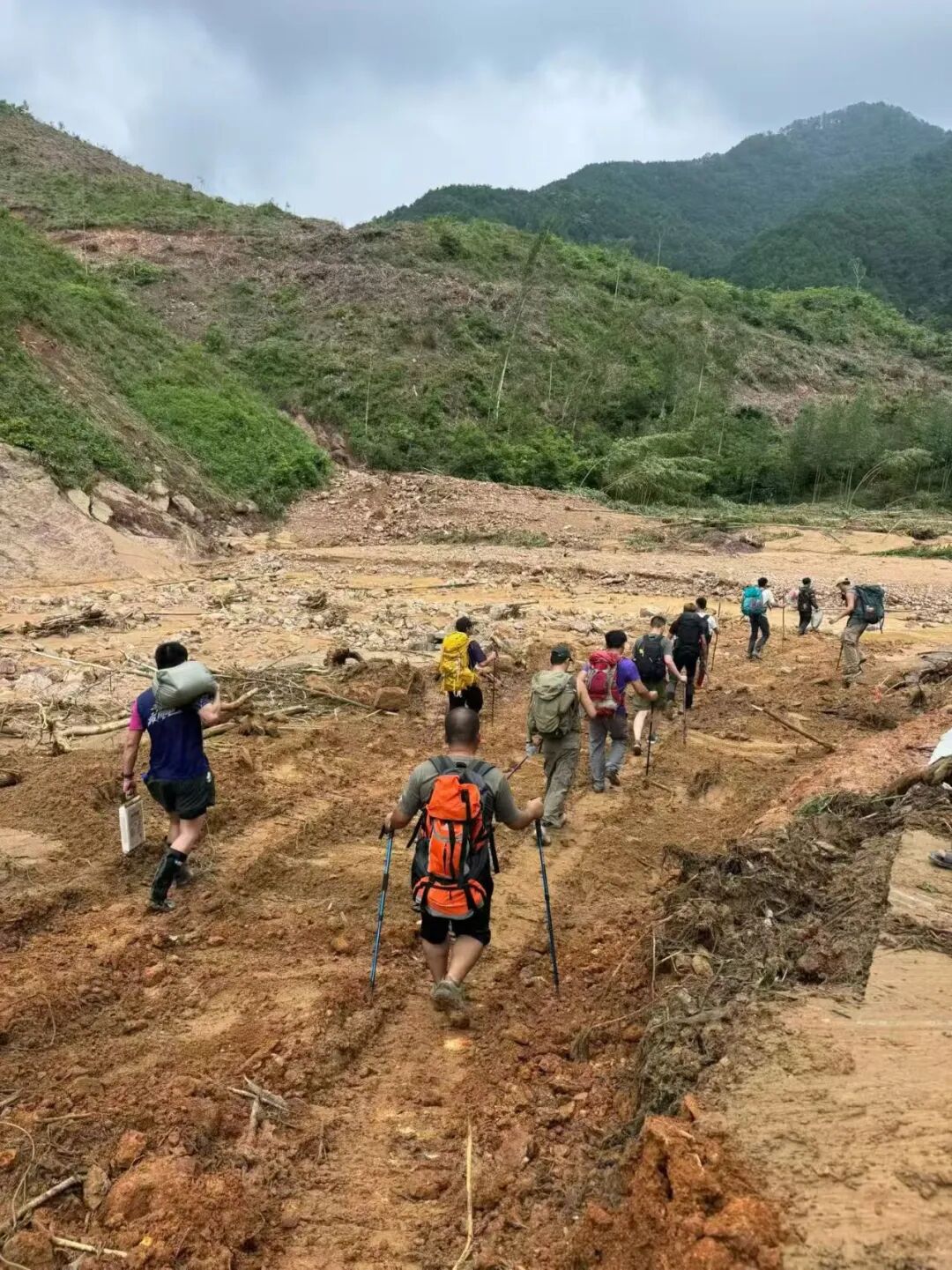 Volunteers carry relief supplies into the flood-stricken mountains