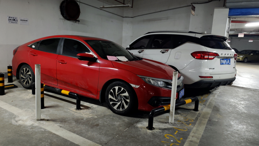 The red car occupying the neighbor's parking space.
